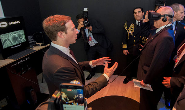 Facebook founder and CEO Mark Zuckerberg (left) gestures next to Peru's President Pedro Pablo Kuczynski (right) who is using a virtual reality headset while visiting the Facebook exhibition booth during the Asia-Pacific Economic Cooperation Summit  in Lima, Peru, on Saturday (Reuters photo)